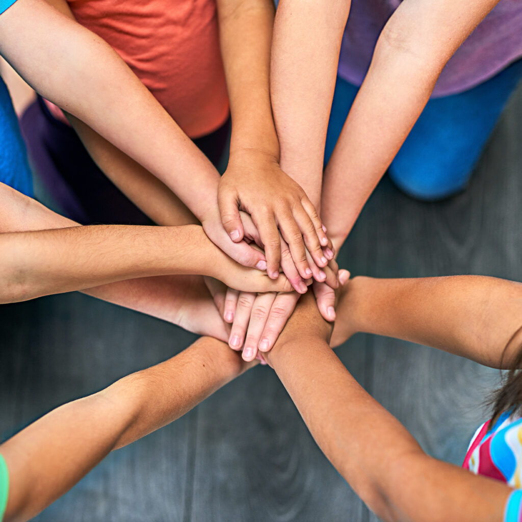 lets do it for the kids. a group of kids joining their hands in solidarity.